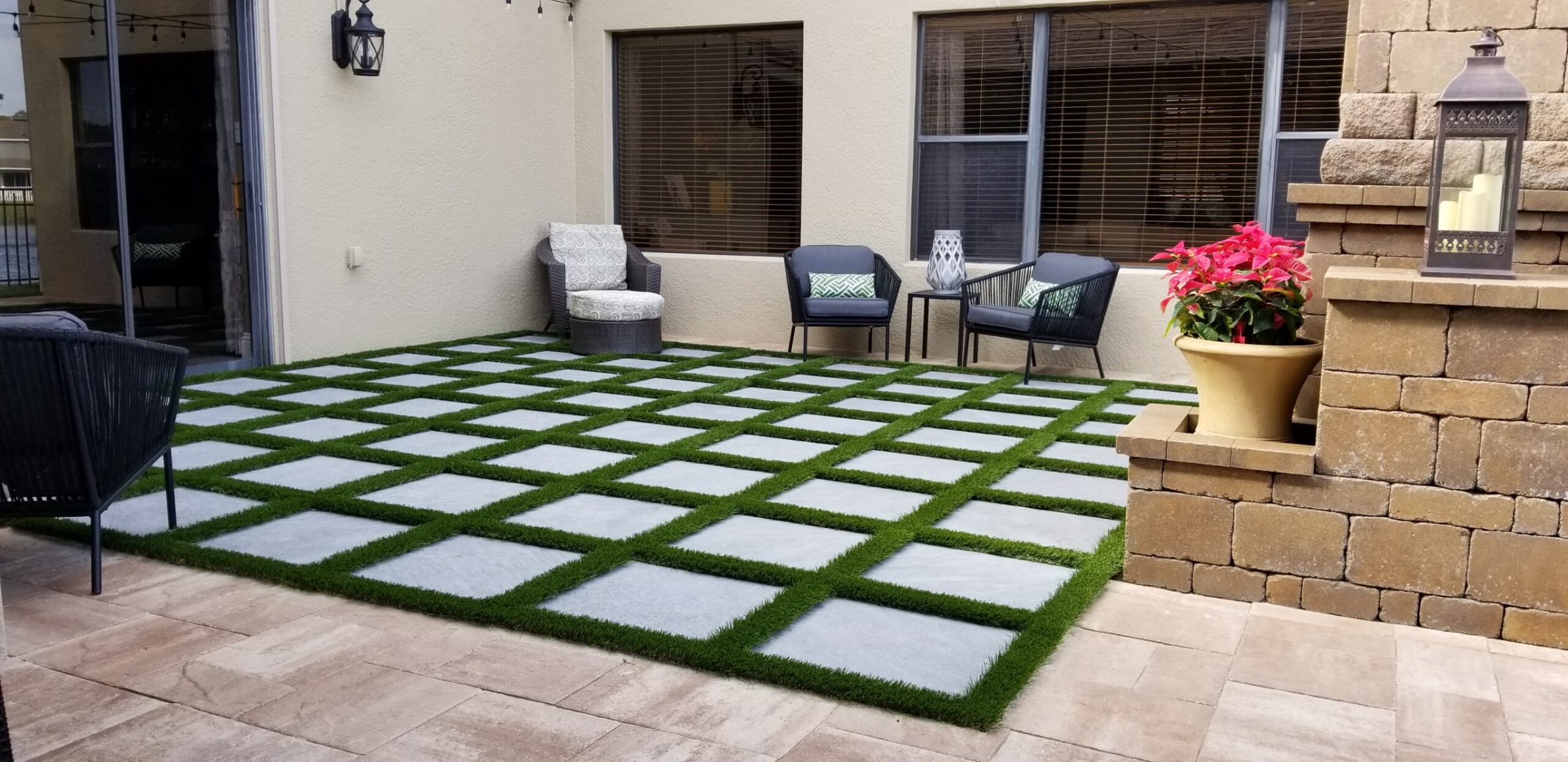 Modern patio with grid design, seating, and potted plant.