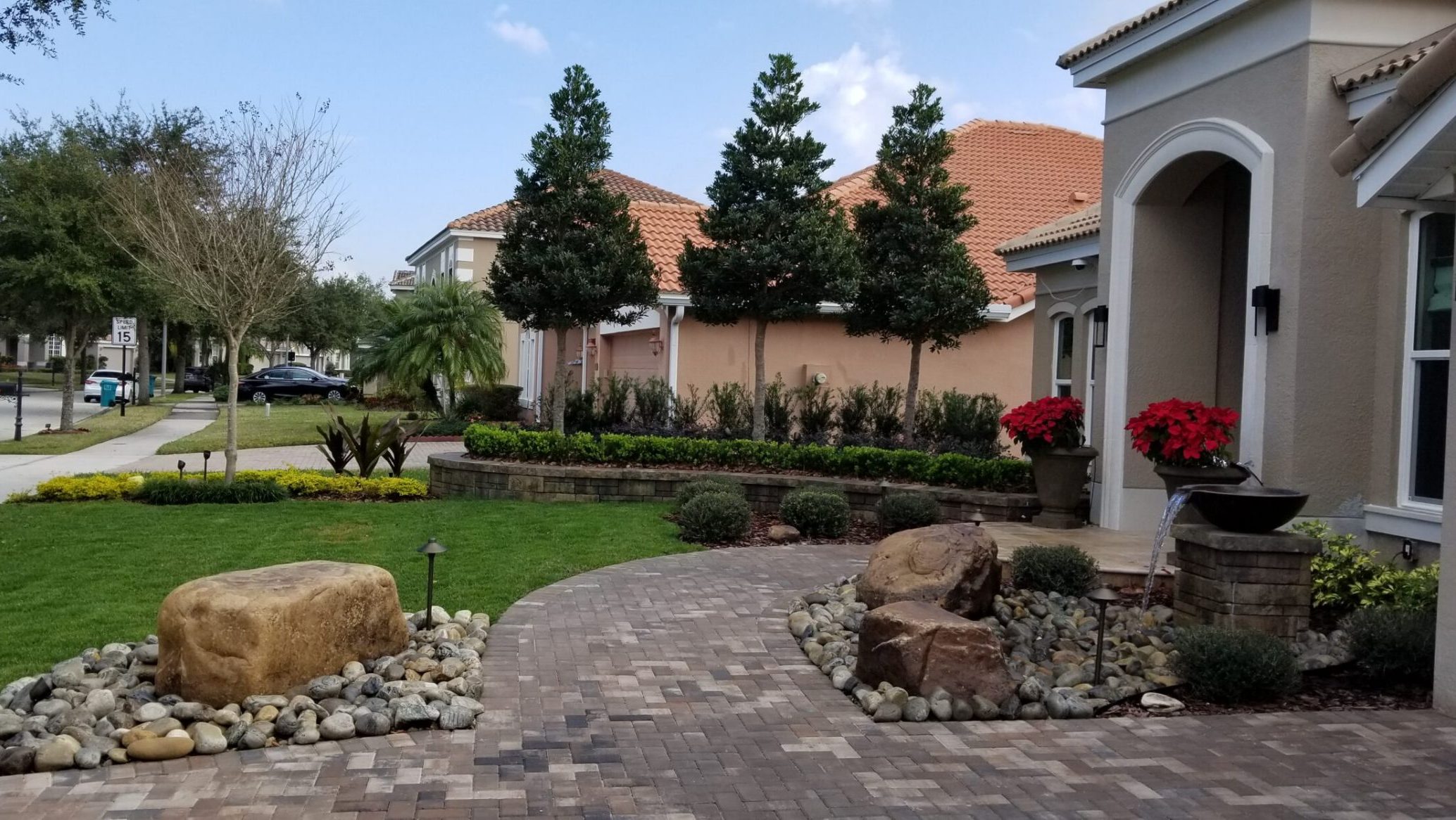 Beautiful landscaped garden with driveway and fountain.