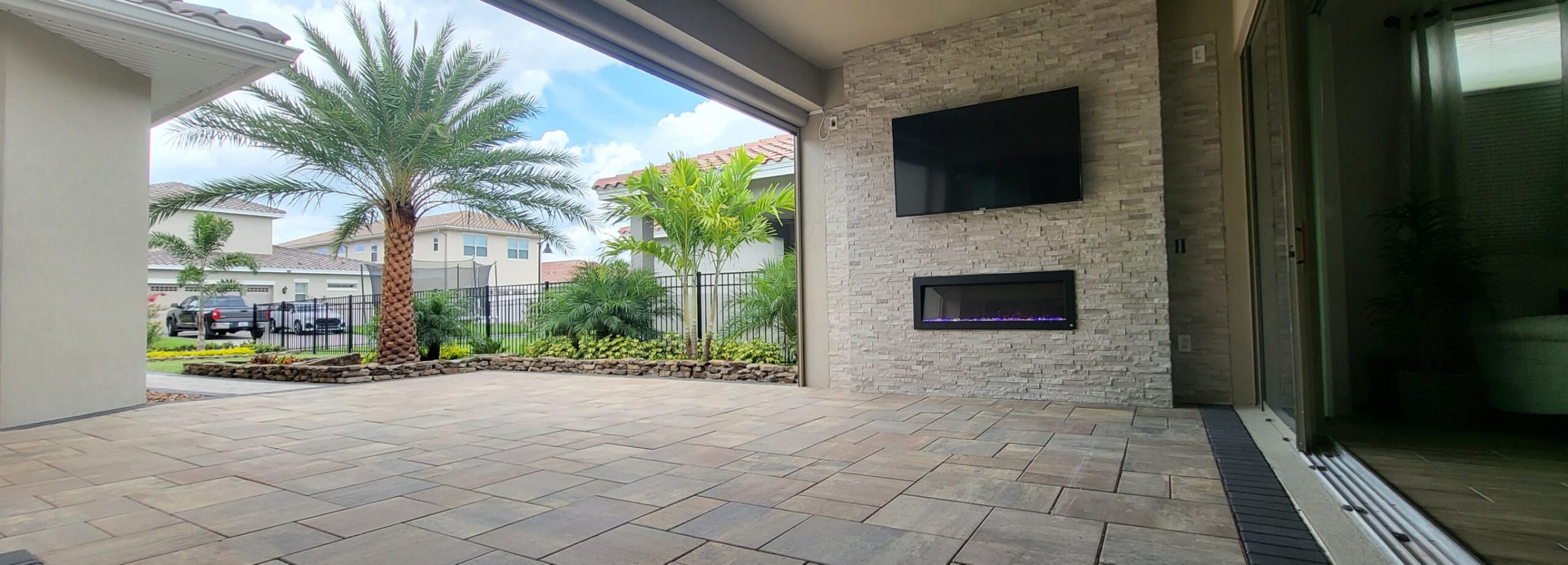Modern patio with palm trees and screen wall.