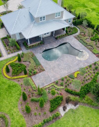 Aerial view of house with landscaped garden and pool.