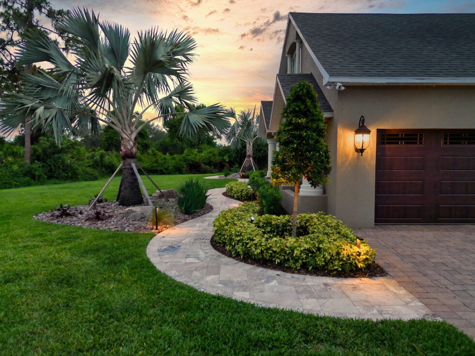 Beautiful house with landscaped garden and palm trees.