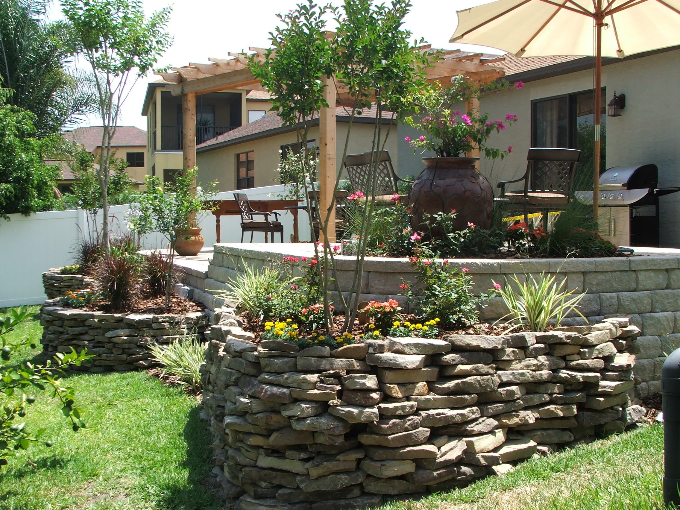 Cozy backyard patio with stone landscaping and pergola.