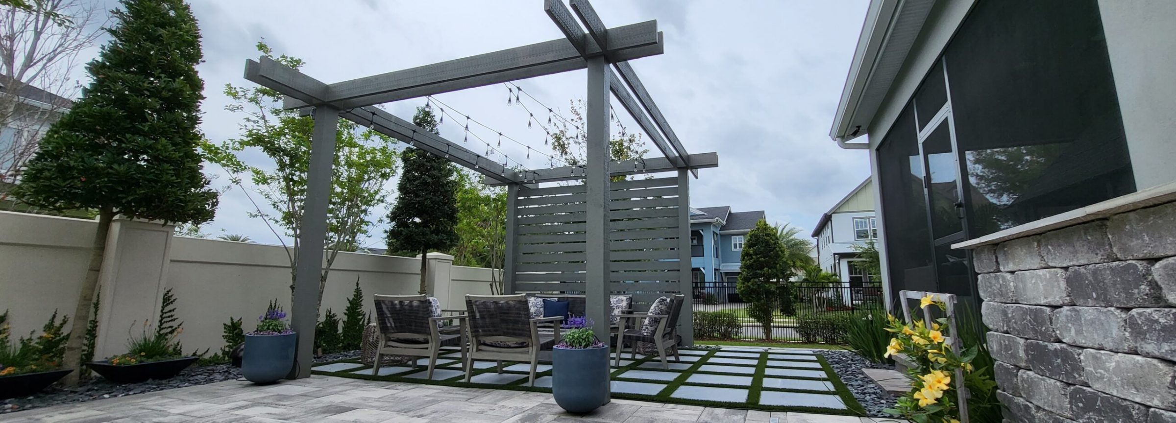 Modern backyard patio with pergola and seating area.