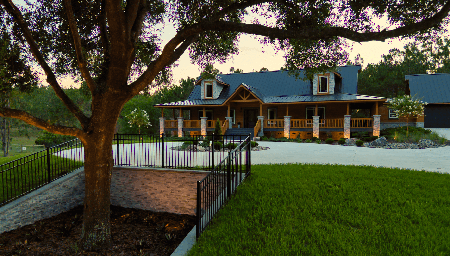 Rustic house with porch and large tree.