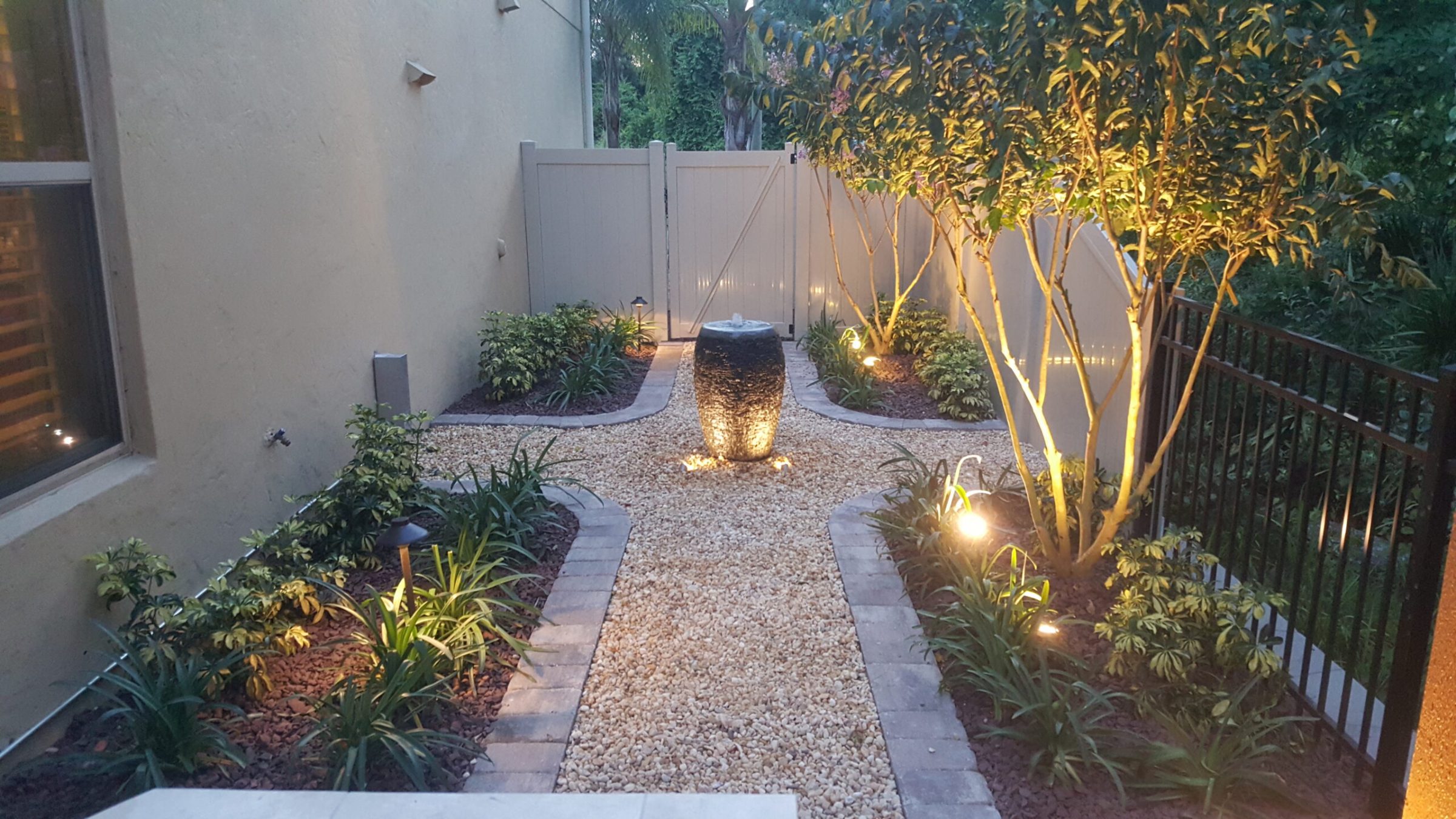 Illuminated garden pathway with central water fountain