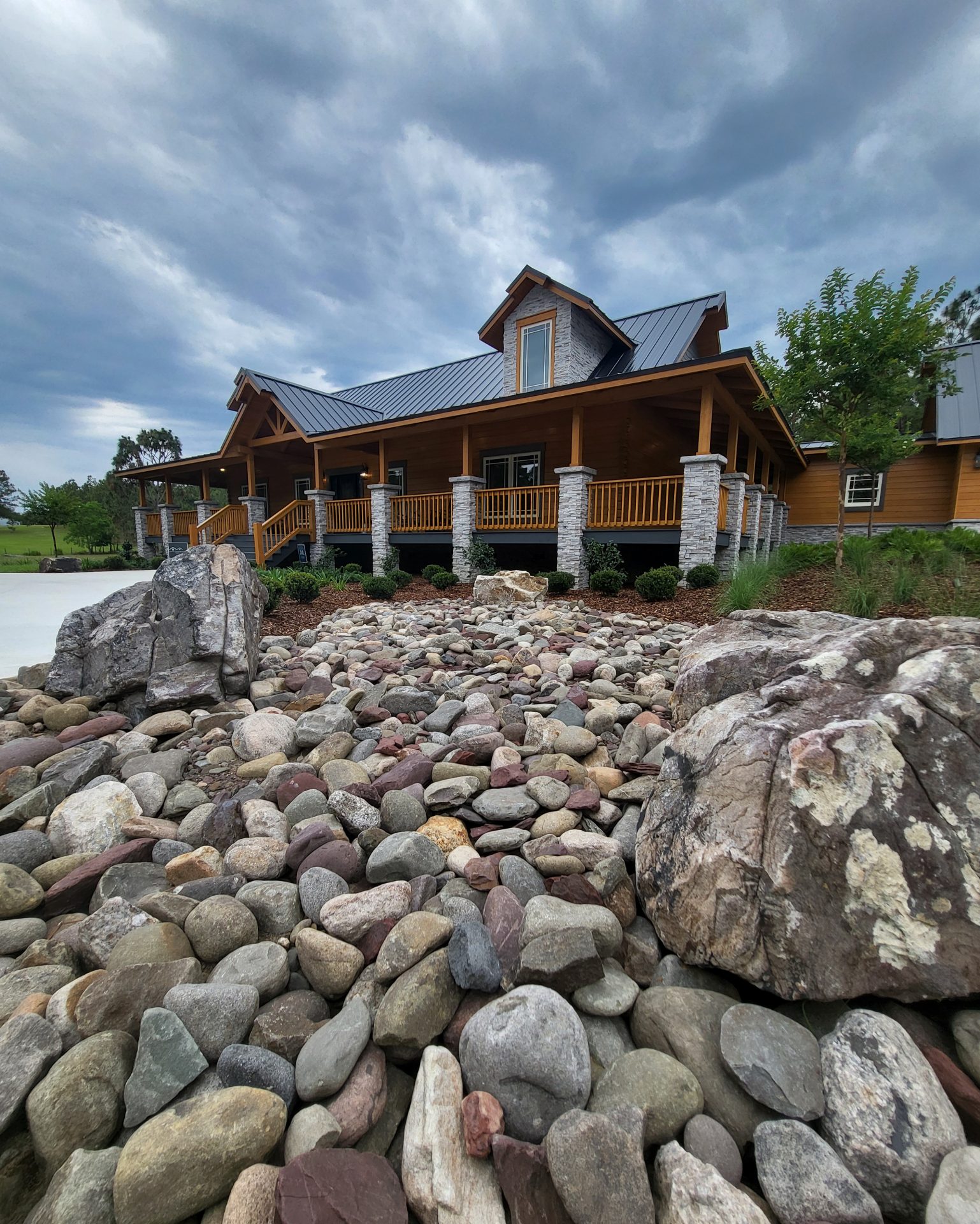 Wooden house with rocky garden landscape.