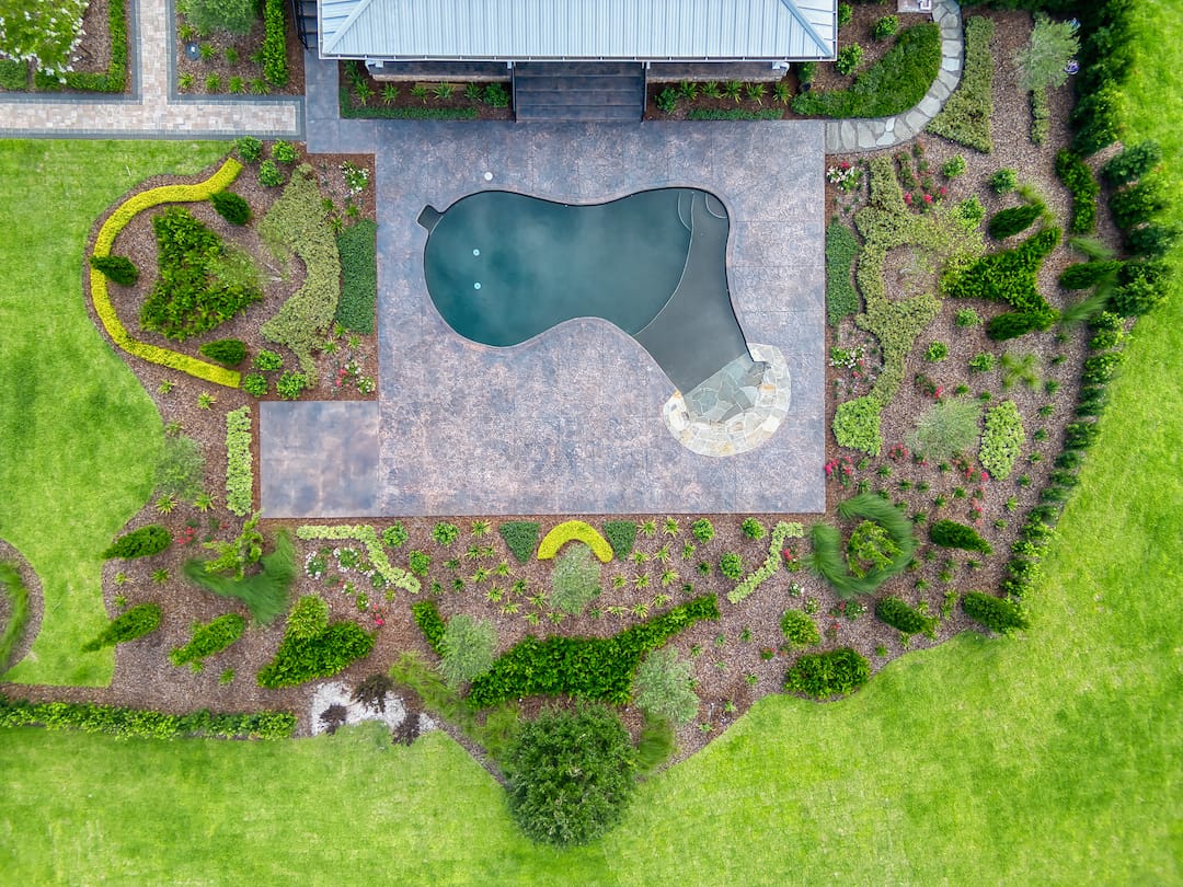 Aerial view of landscaped yard with pool.