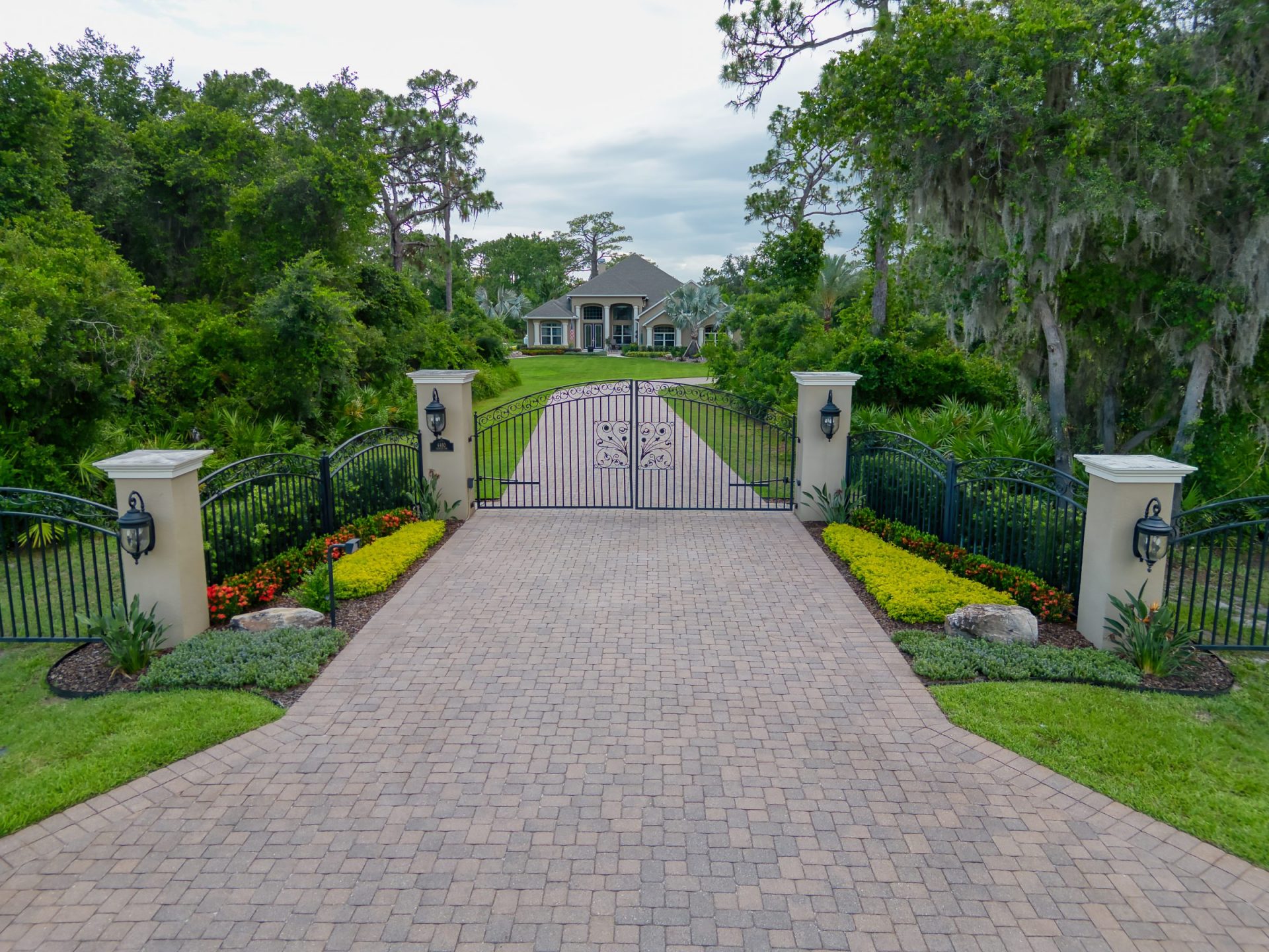Luxurious gated driveway leading to elegant house