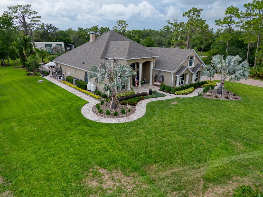 Suburban house with large lawn and landscaping.