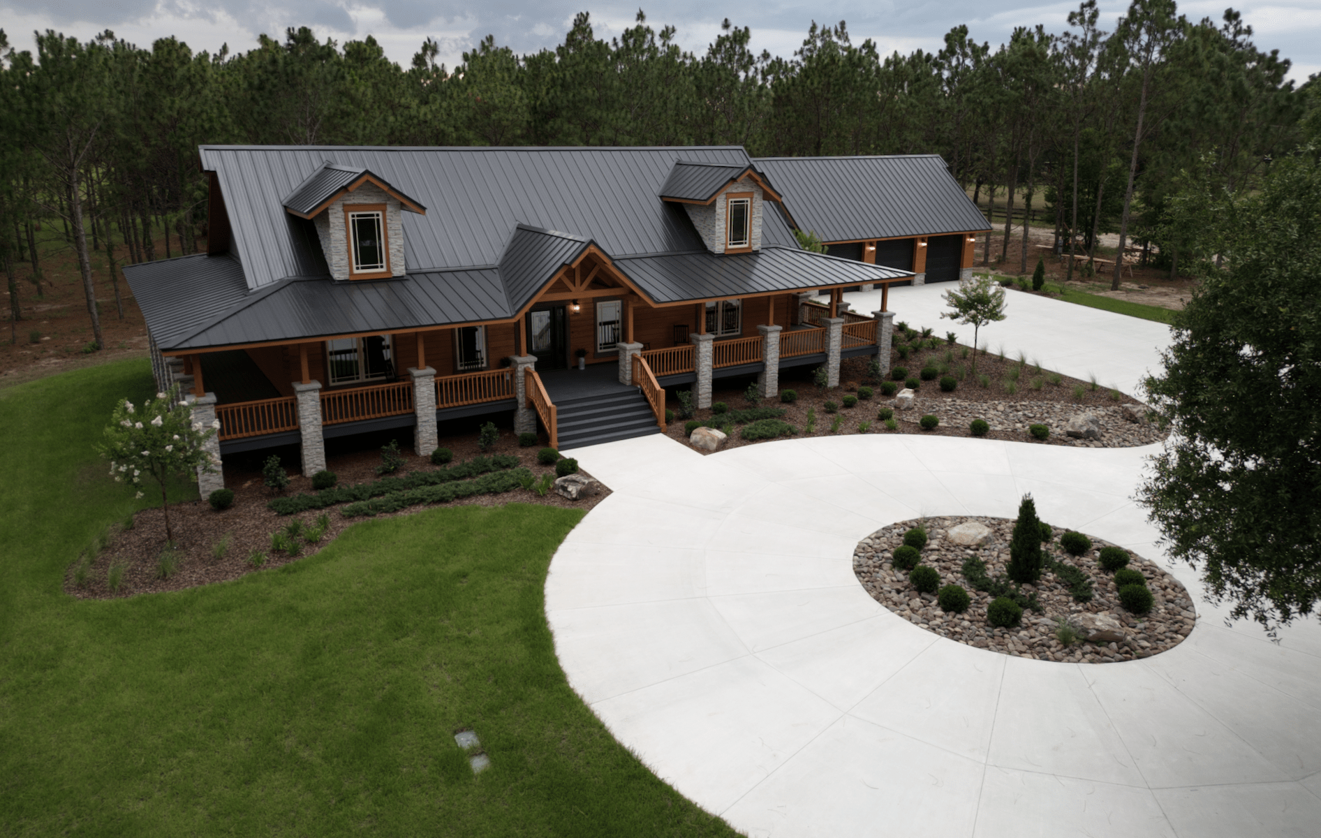 Spacious log cabin with circular driveway, surrounded by trees.