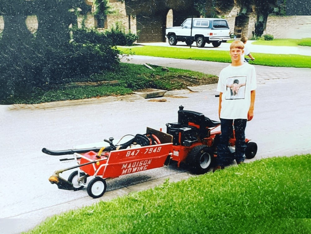 Person with lawn mower trailer on street