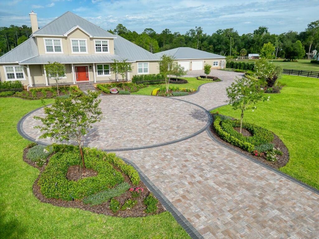 Curved paver driveway with landscaped front yard