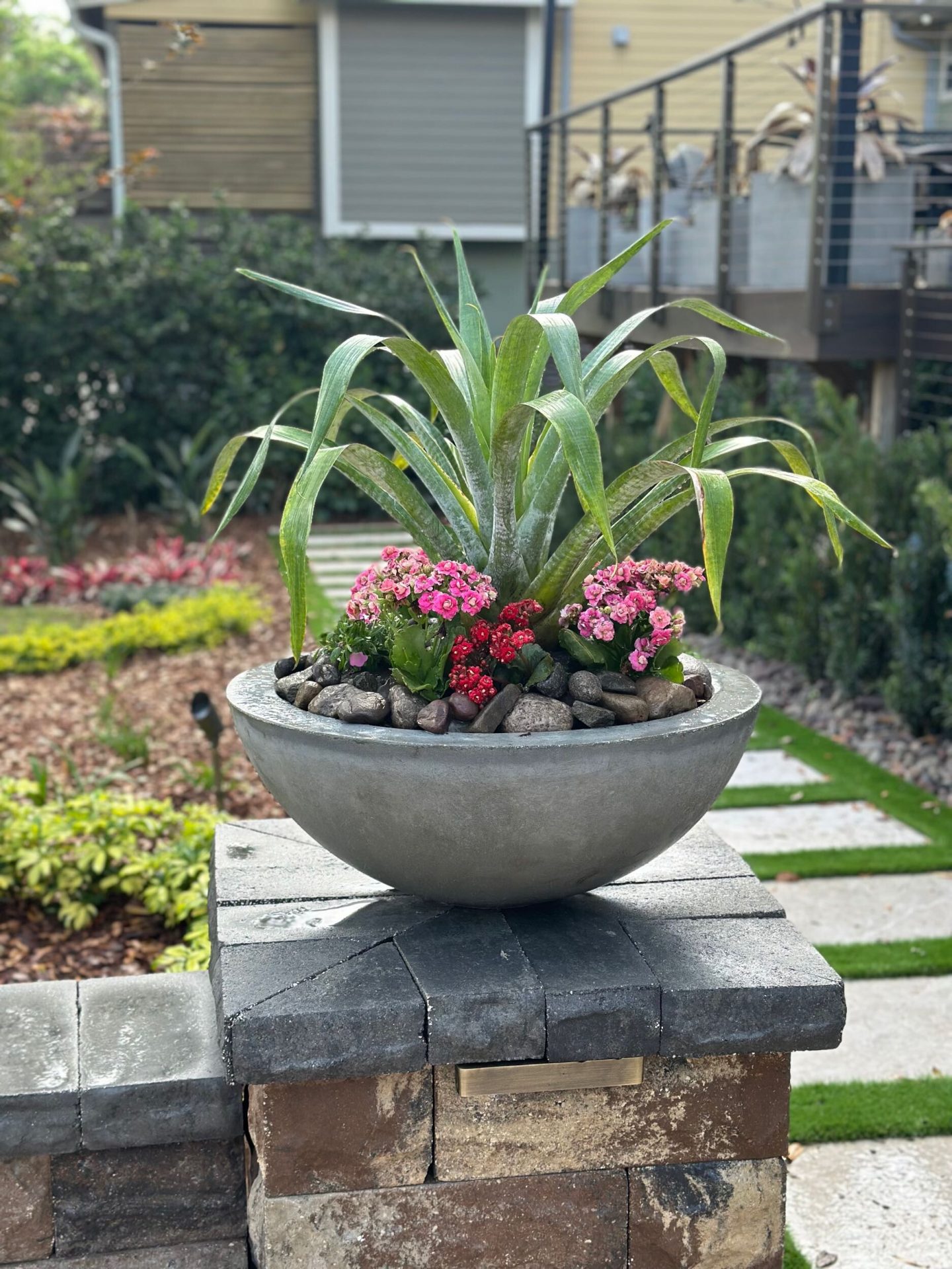 Colorful planter with succulents on patio.