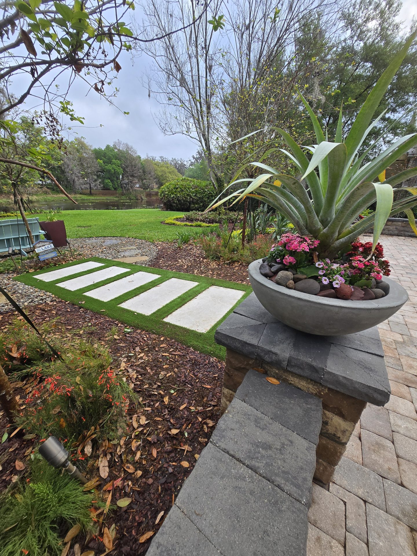 Garden path with plants and pond view.